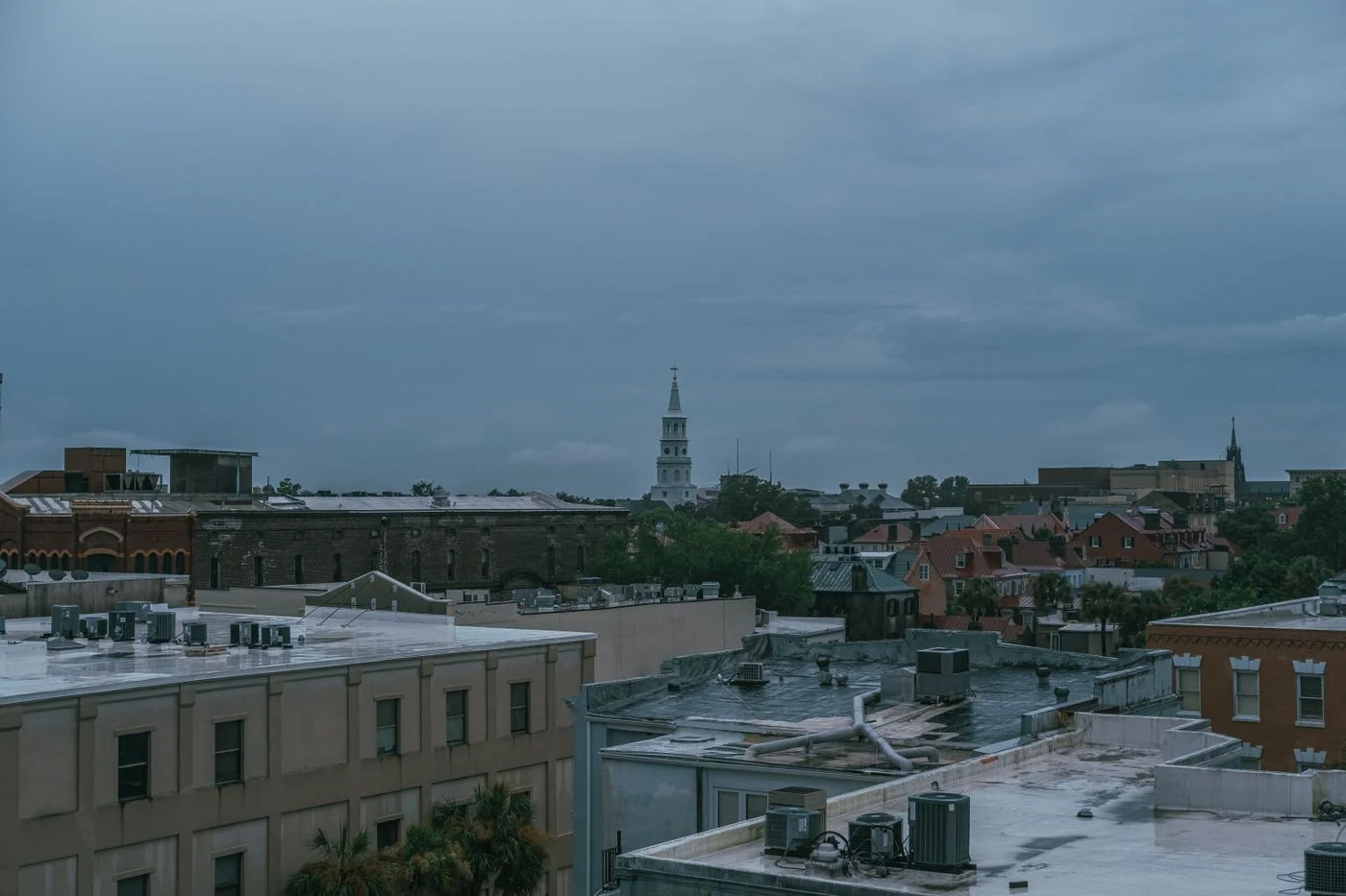 Charleston rooftops and St Michael's Church under a cloudy sky