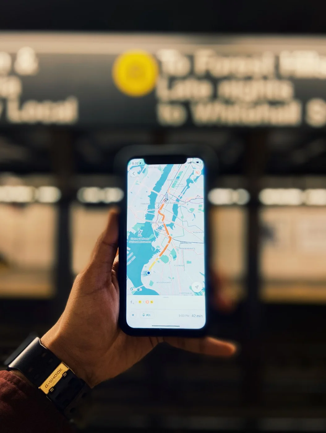 A phone displaying a New York City map inside a subway station