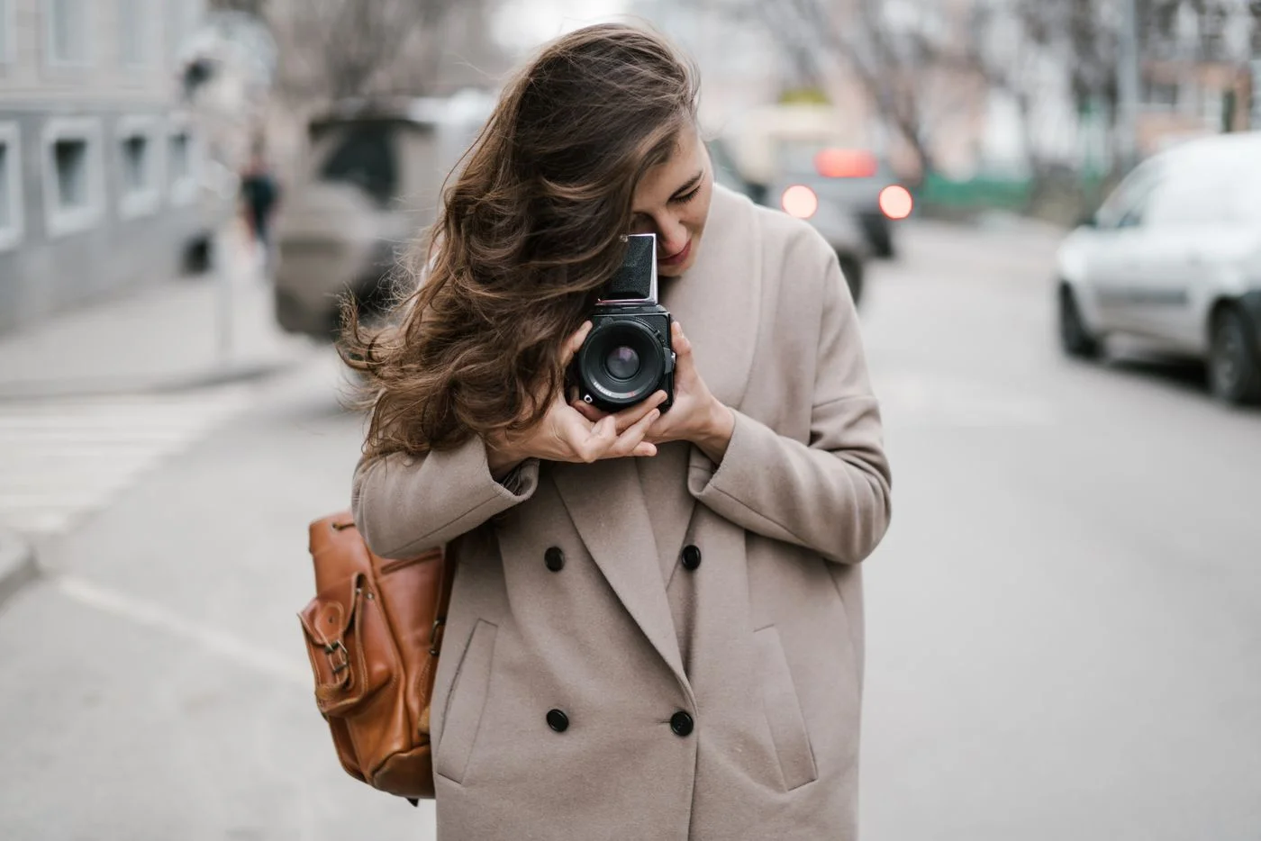 A traveler using a camera while exploring a city street
